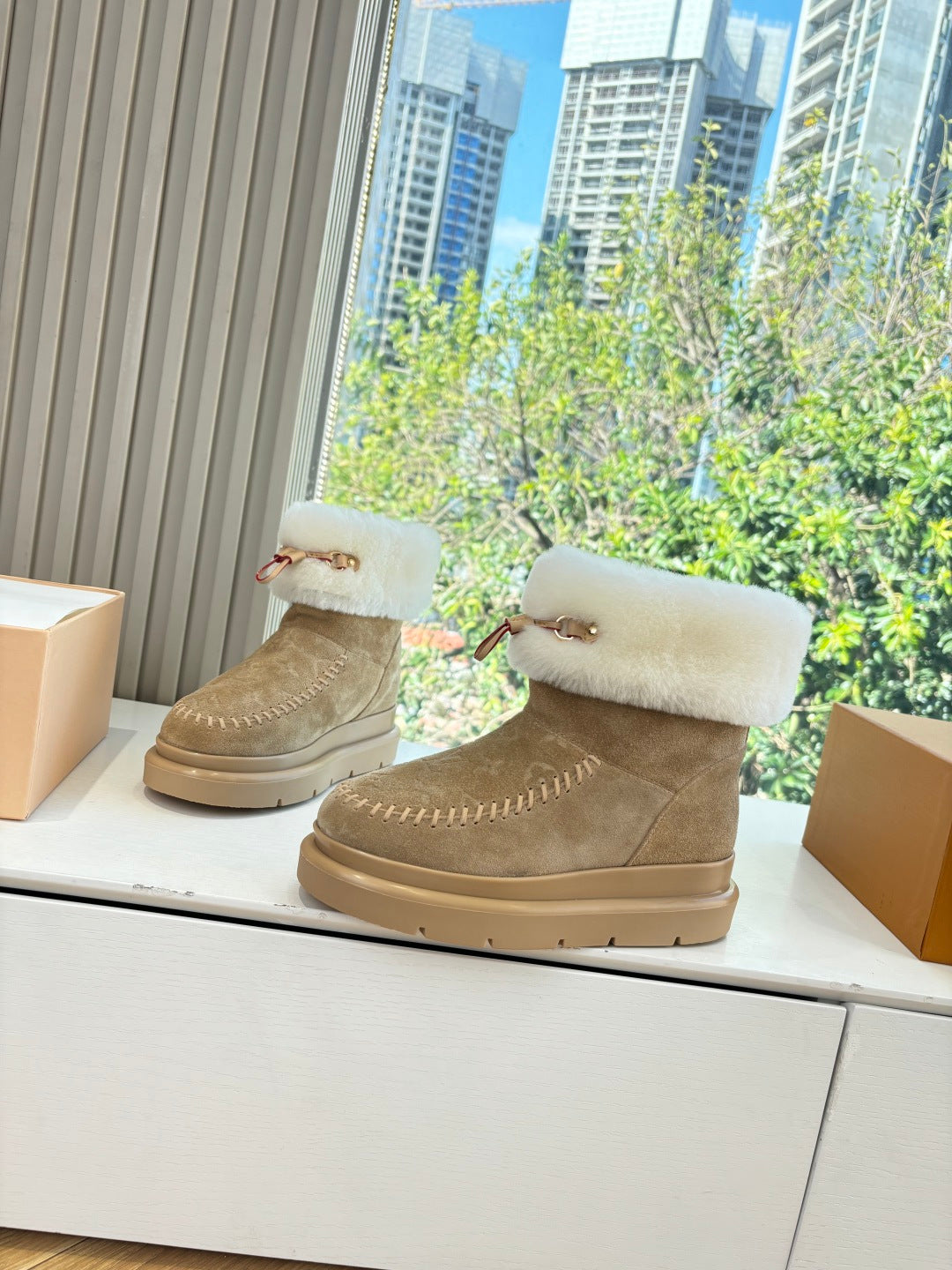 Tan suede ankle boots with white shearling collar and side logo strap
