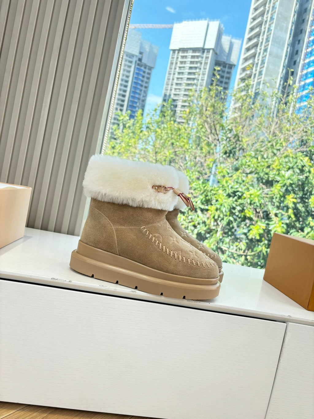 Tan suede ankle boots with white shearling cuff and decorative stitching trim