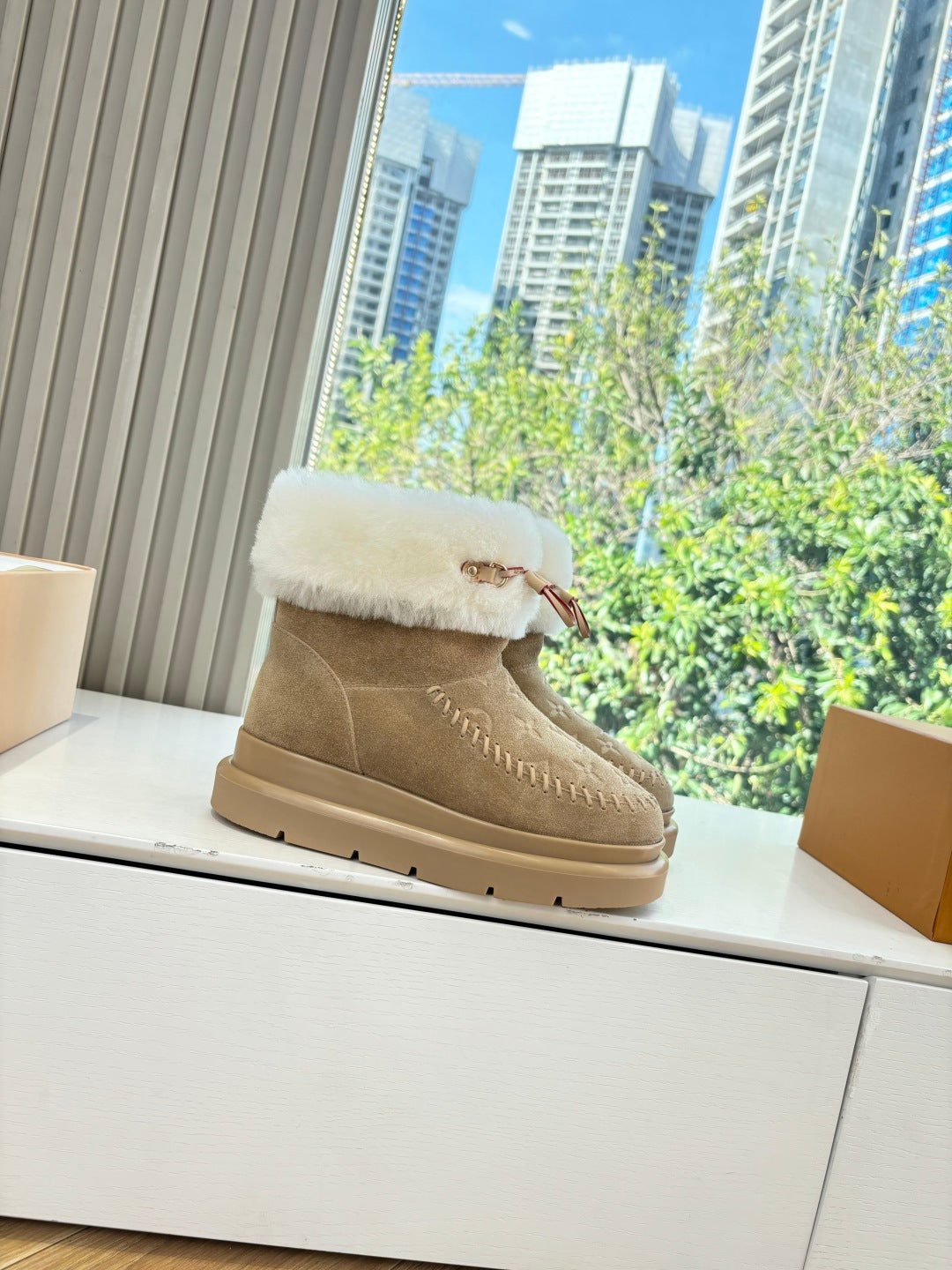 Tan suede ankle boots with white shearling cuff and decorative stitching trim