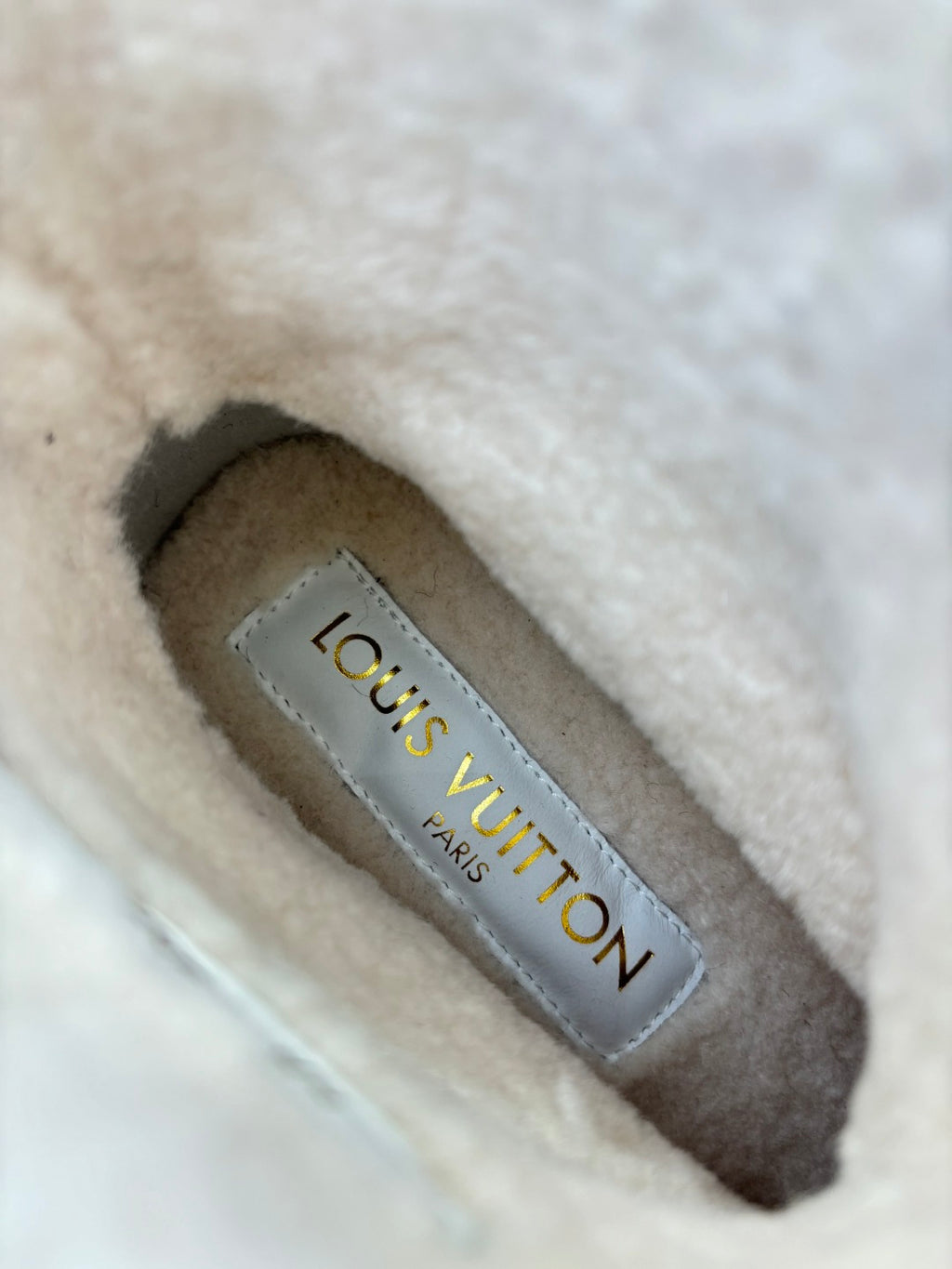 Louis Vuitton insole label inside tan shearling boot reading “Louis Vuitton Paris”