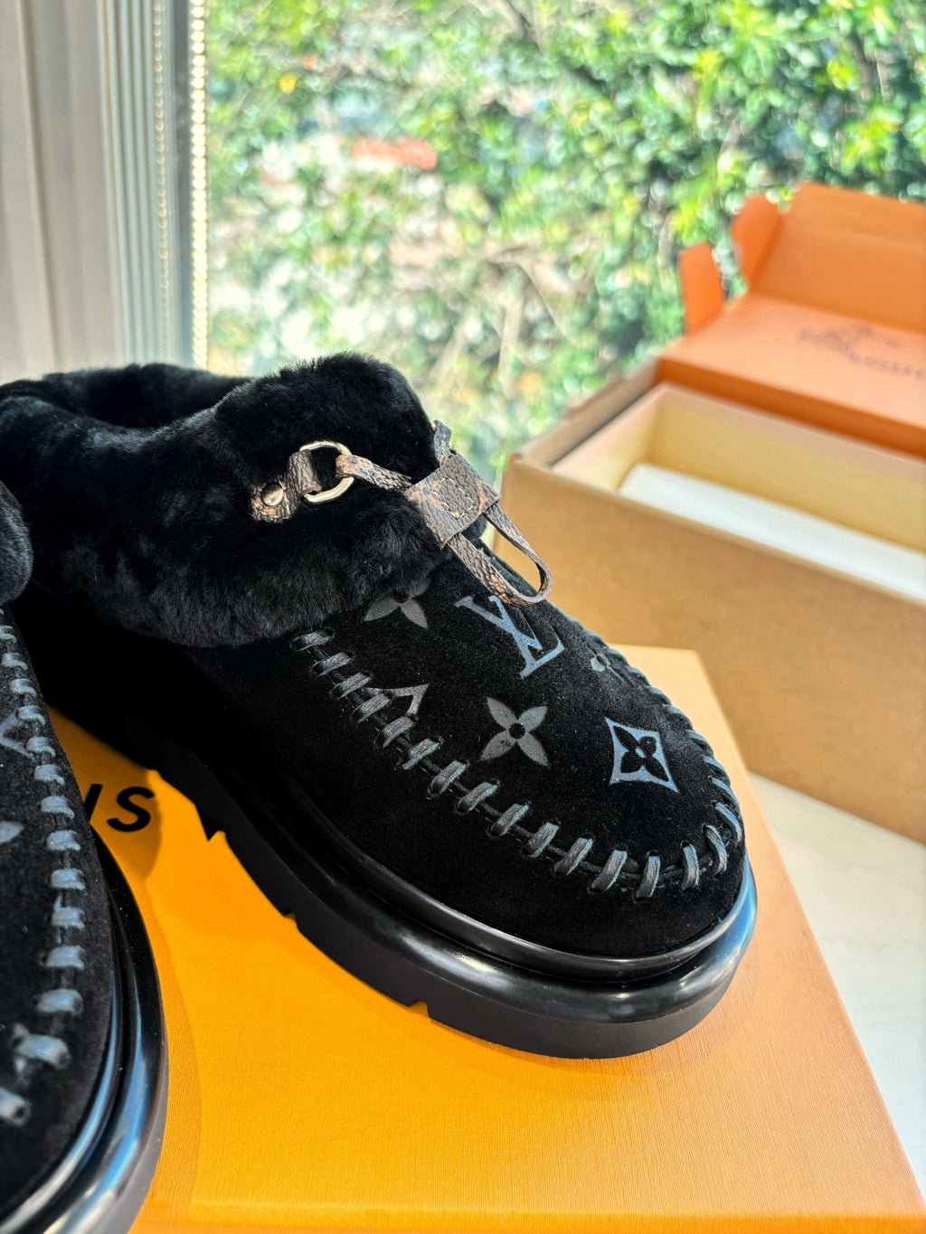 Close-up of Louis Vuitton unisex black velvet loafer with monogram stitching and silver buckle