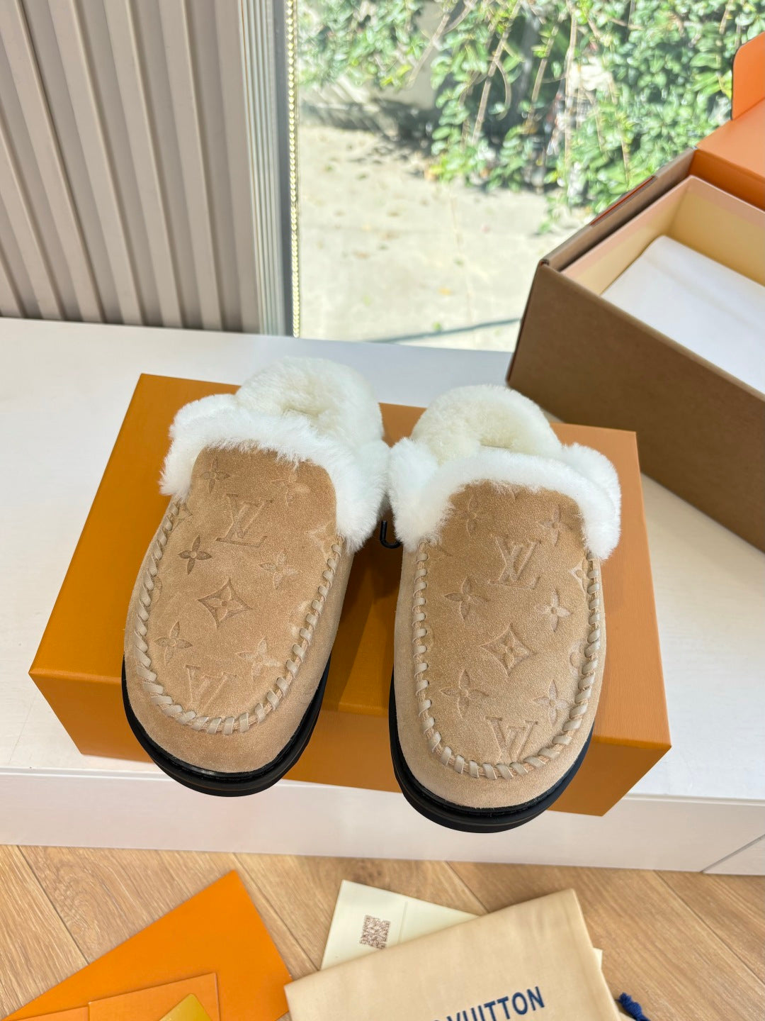 Louis Vuitton shearling moccasin slippers, front view in tan suede with black sole