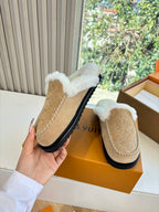 Louis Vuitton shearling moccasin slipper shown by hand, tan suede and white fur