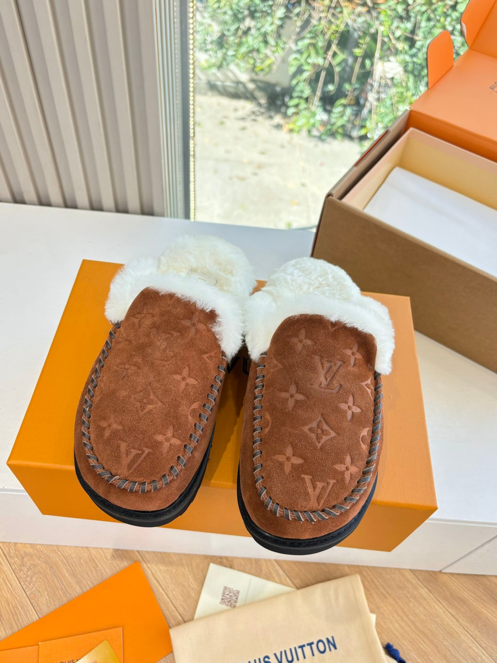 Pair of brown monogram suede shearling slippers with white fleece trim