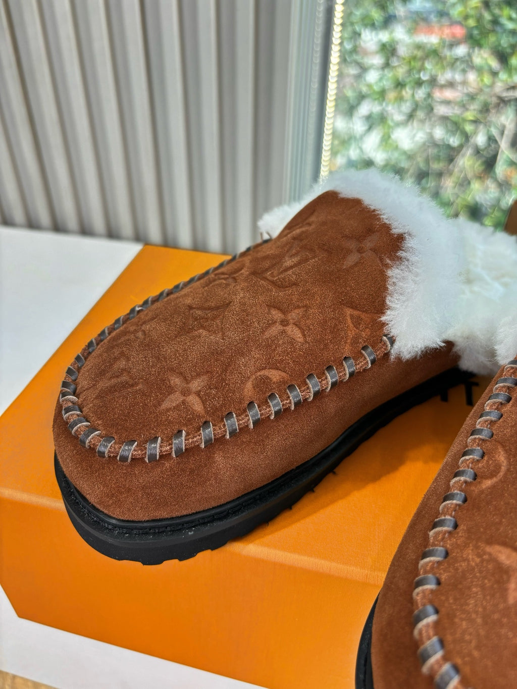 Brown monogram suede slipper with white shearling trim and rope-like stitching