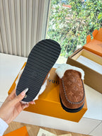 Brown suede shearling slipper with white fleece, showing textured black sole