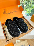 Black Louis Vuitton monogram slippers with fuzzy lining, shown in a box set