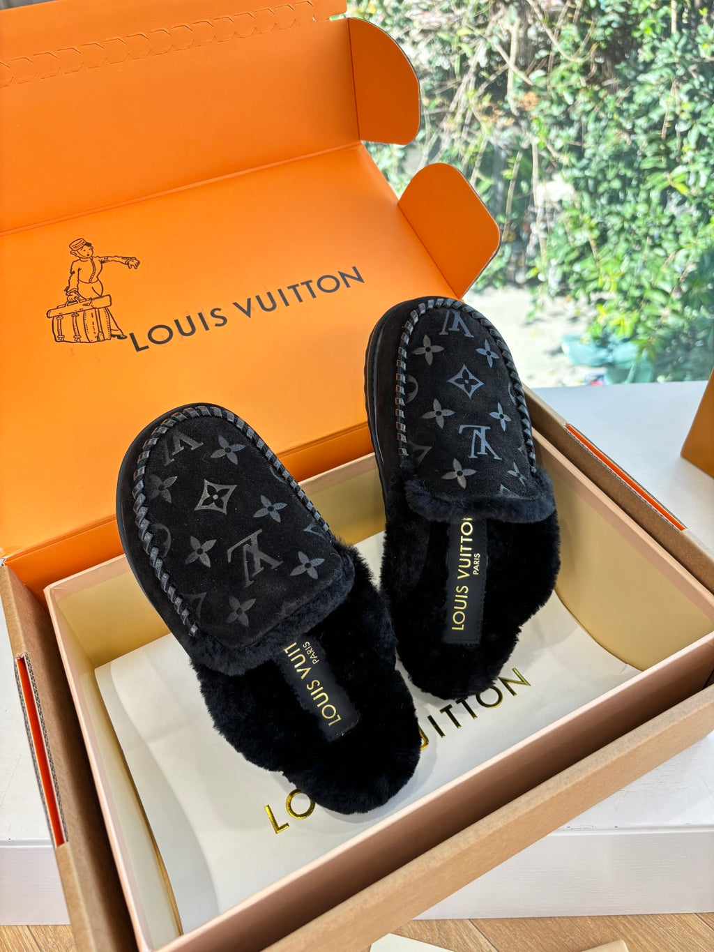Pair of black Louis Vuitton monogram slippers with plush lining and moc-stitched edge