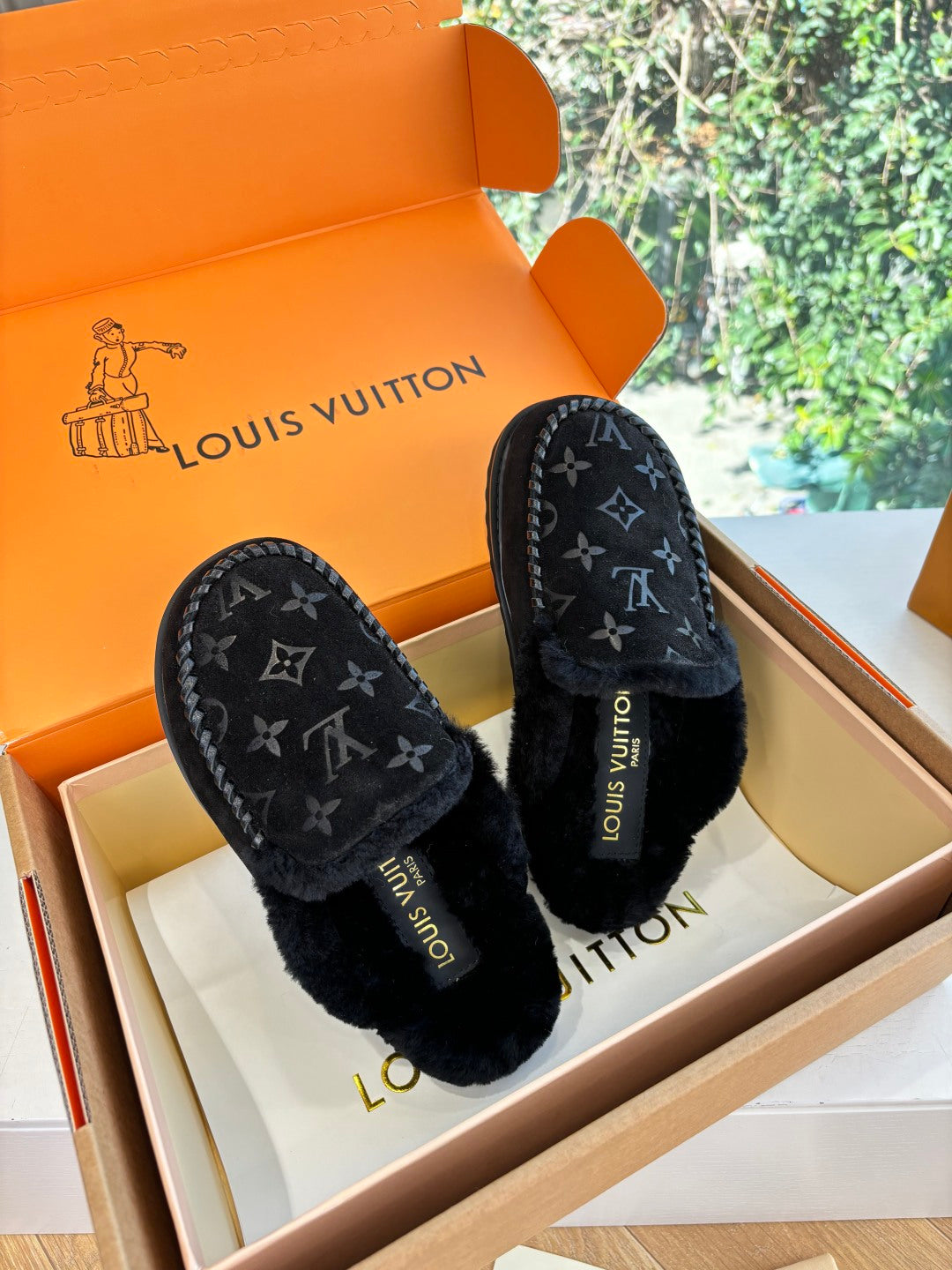 Pair of black Louis Vuitton monogram slippers with plush lining and moc-stitched edge