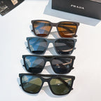 Prada sunglasses stack with amber, blue, and green-tinted lenses on dark frames