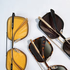 Prada sunglasses set with yellow and dark-tinted lenses on gold-tone frames