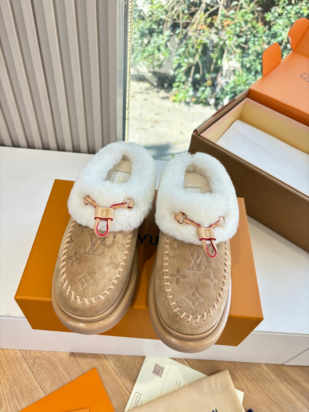 Pair of tan Louis Vuitton shearling loafers in box, white fur trim and front strap