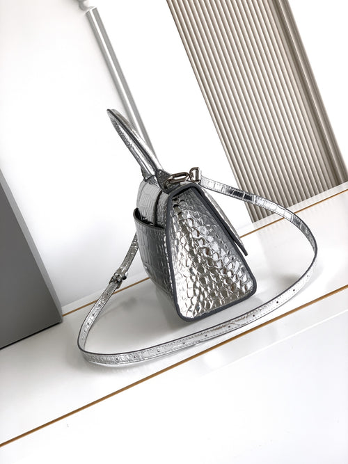 Silver croc-embossed mini bag with top handle, adjustable shoulder strap, and clasp