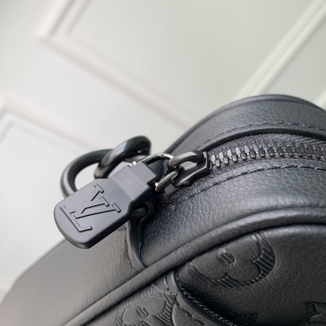 Louis Vuitton monogram bag close-up of zipper pull, ring, and black leather trim