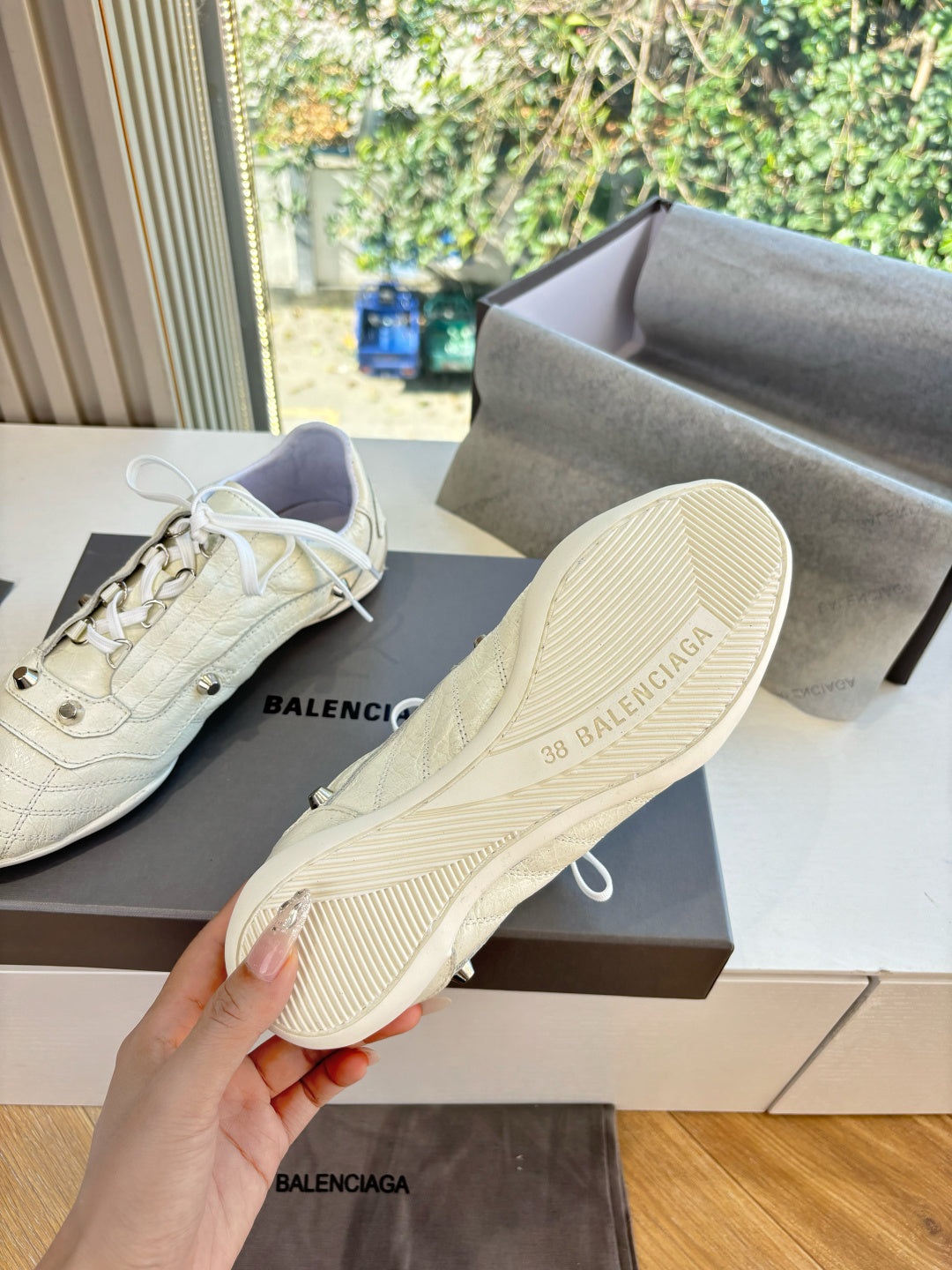Cream sneakers showing textured rubber sole and sidewall ridges