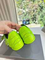 Balenciaga lime green lace-up sneakers, back view held in a hand