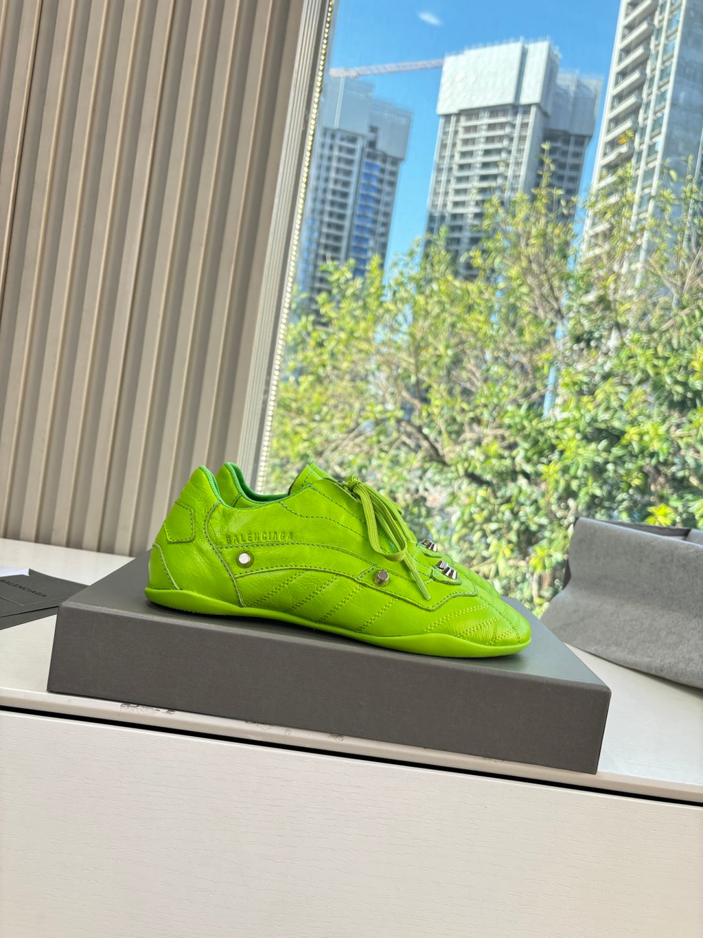Balenciaga lime green lace-up low-top sneaker, side profile on a box