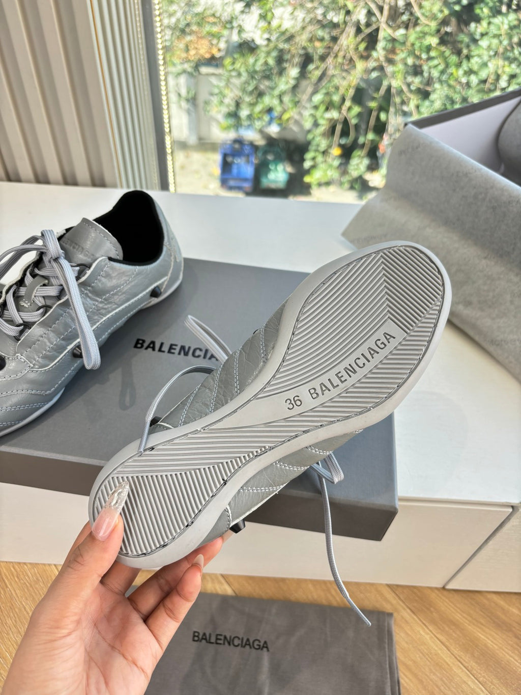 Light gray sneaker outsole with striped tread and brand text on the heel