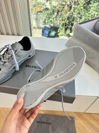 Light gray sneaker outsole with striped tread and brand text on the heel