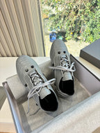 Light gray lace-up sneakers, side view with eyelets and black tongue lining