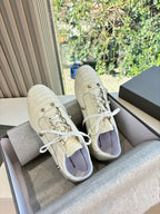 Pair of cream lace-up sneakers with padded collars and contrast inner lining