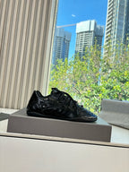 Black leather lace-up sneaker with textured pattern and blue sheen, single shoe