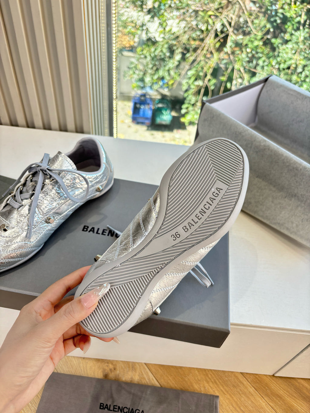 Silver lace-up sneaker outsole with striped tread and Balenciaga logo.