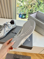 Silver lace-up sneaker outsole with striped tread and Balenciaga logo.