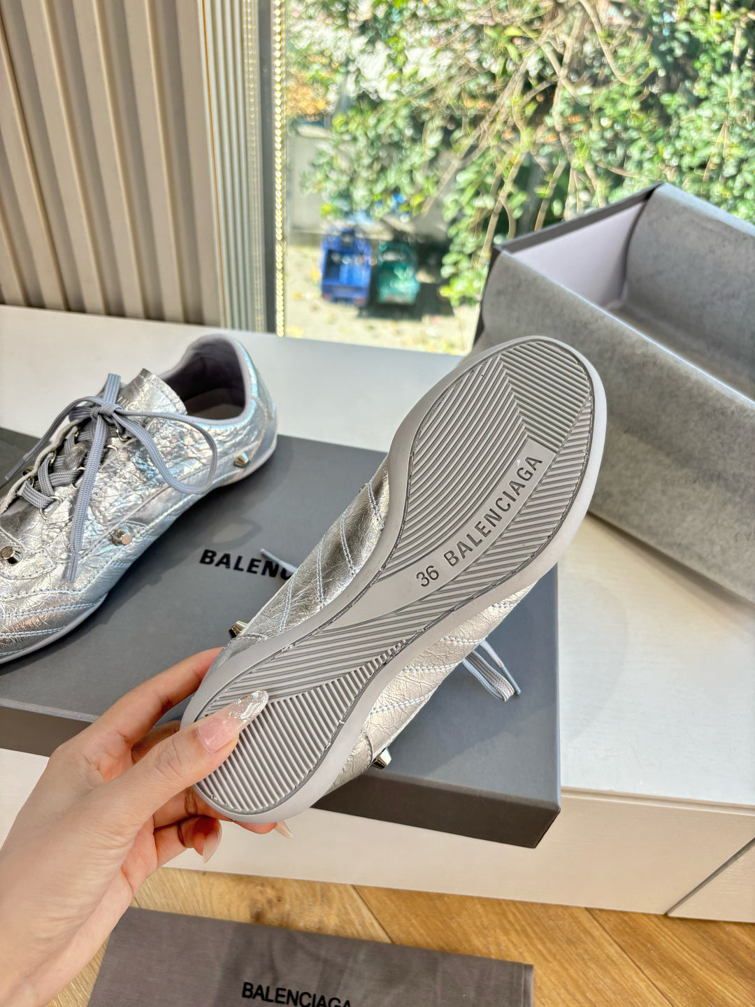 Silver lace-up sneaker outsole with striped tread and Balenciaga logo.