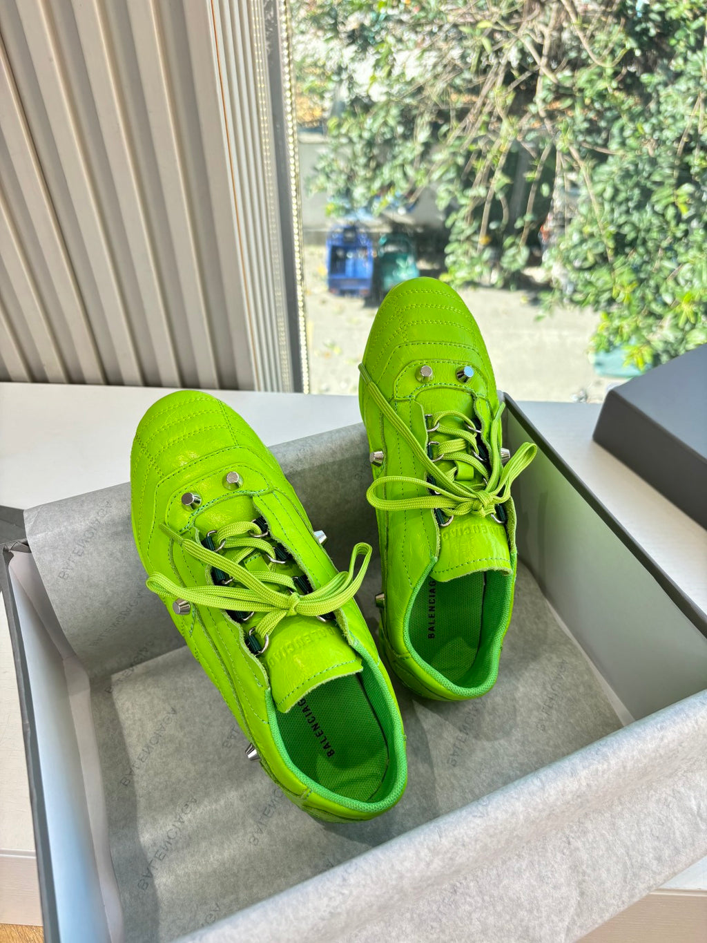 Balenciaga lime green lace-up sneakers, side view, with perforated toe and metal eyelets