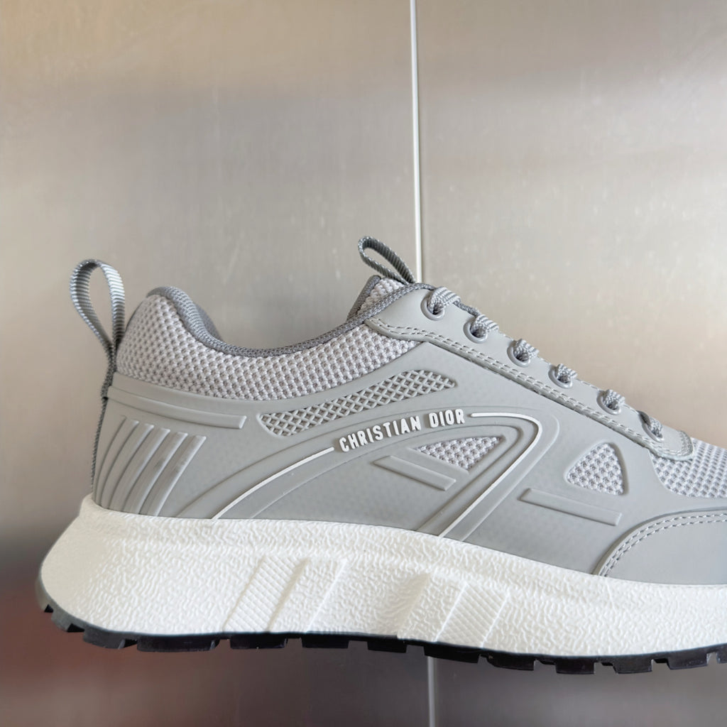 Light gray lace-up sneaker with sculpted logo panel, textured tread, and thick white sole