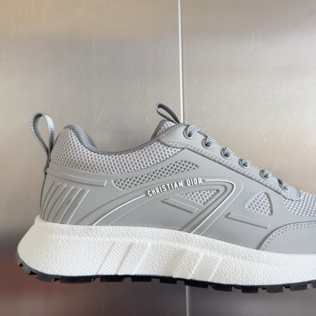 Light gray lace-up sneaker with sculpted logo panel, textured tread, and thick white sole