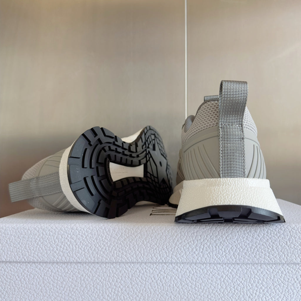Light gray lace-up sneaker showing treaded outsole, padded heel collar, and chunky midsole
