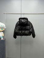 Prada black long puffer jacket with hood and button placket, hanging on rack