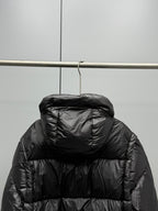 Prada black long puffer jacket back view with hood, hanging on a rack