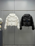 Prada long puffer jackets in white and black, hanging side by side on a rack
