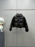 Prada black long puffer jacket with hood and front button placket, hanging view