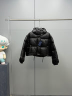 Prada black long puffer jacket with hood and front button placket, hanging view