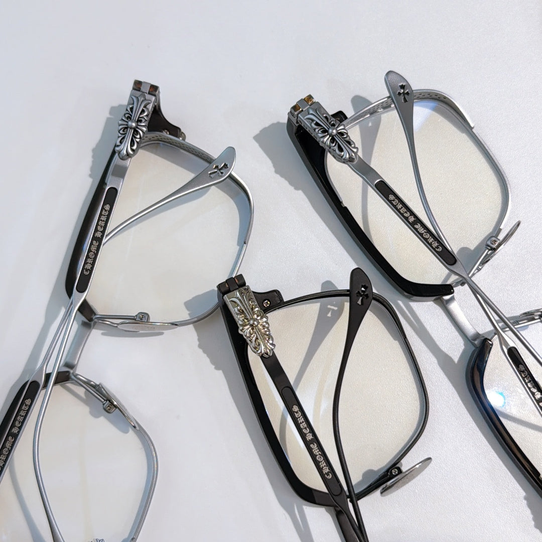 Set of eyeglasses with black and silver frames, clear lenses, and ornate temple details.