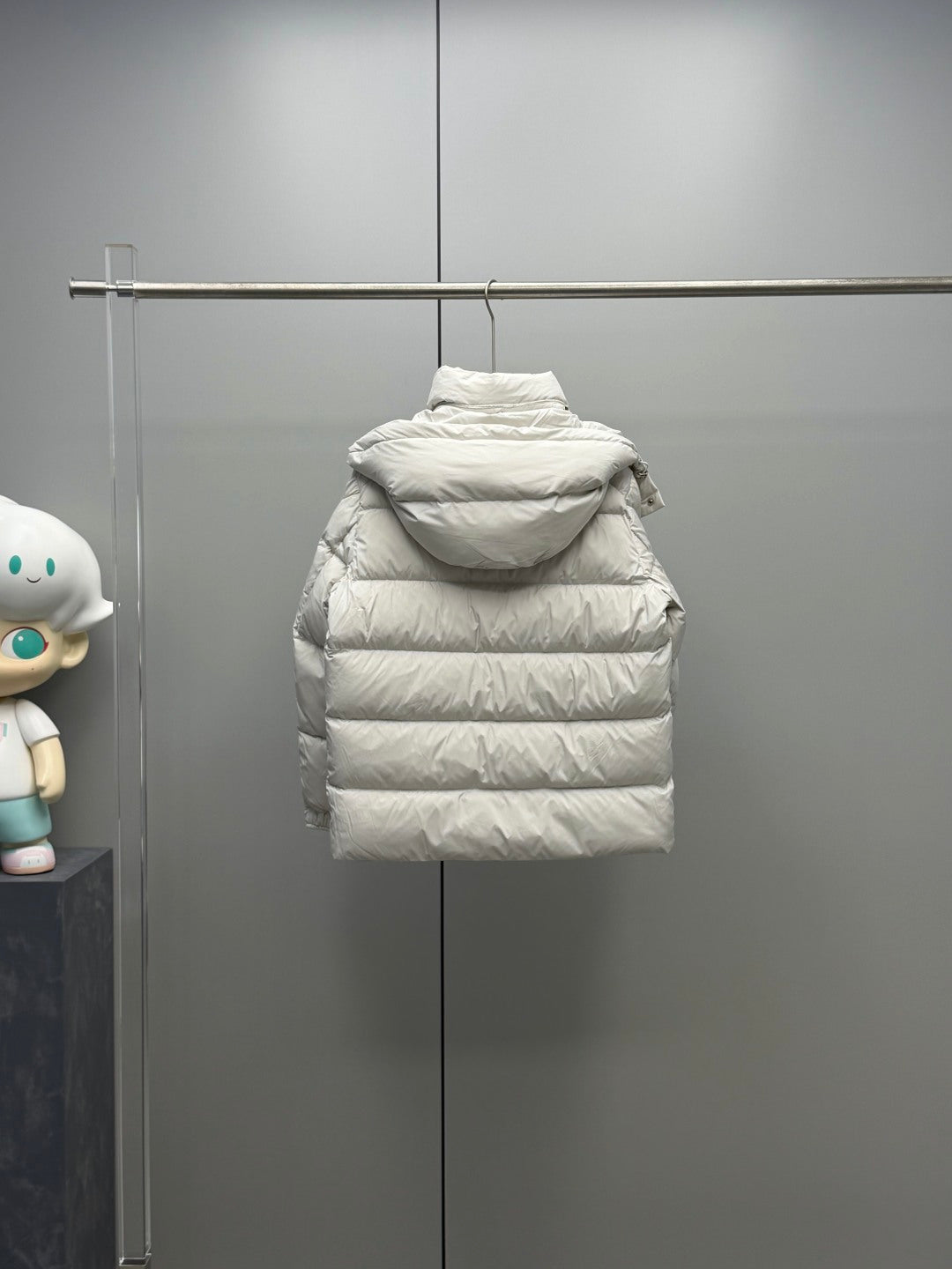 White hooded puffer jacket on hanger with front and back quilted panels
