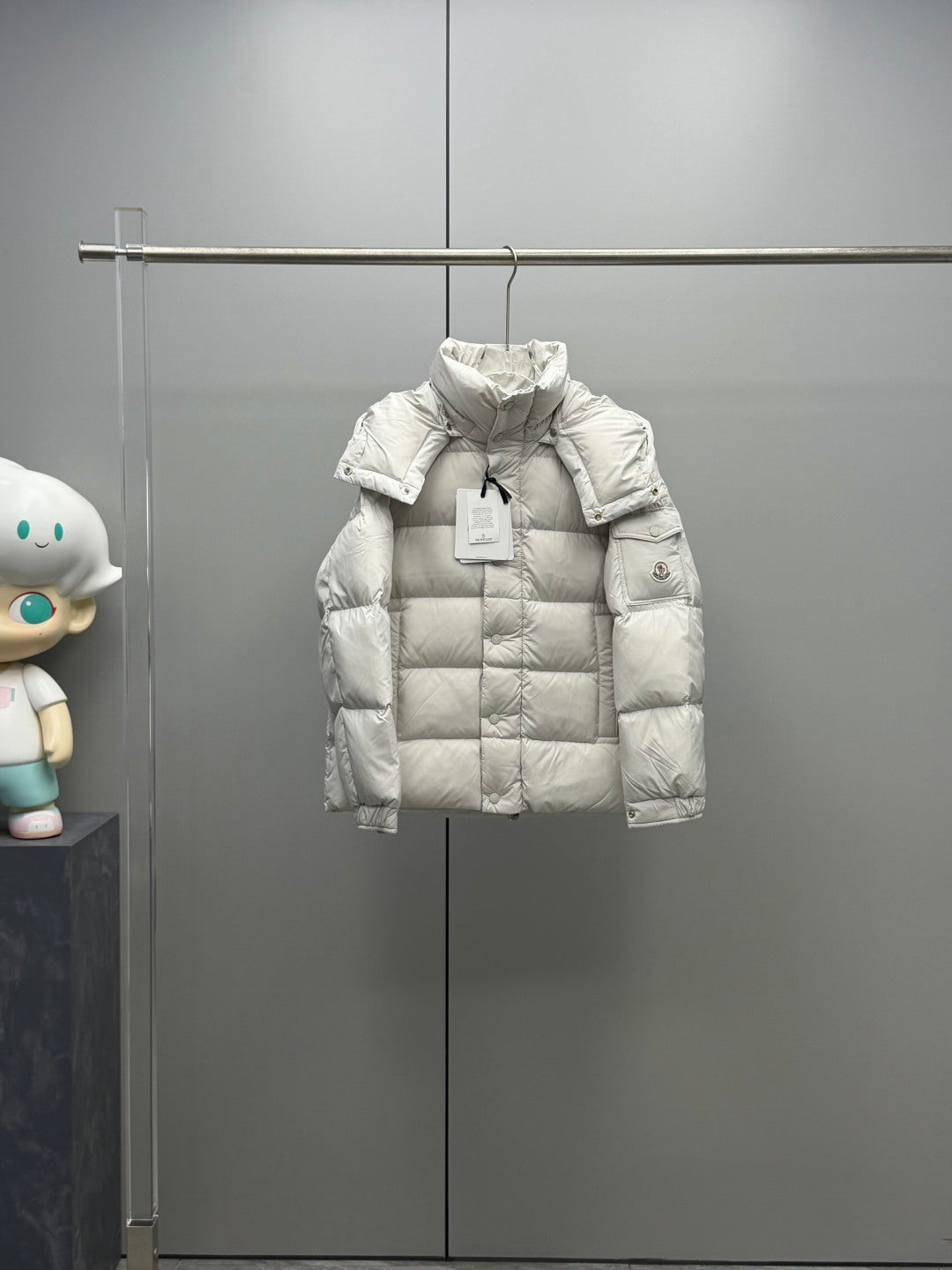 White hooded puffer jacket with quilted panels and front snap placket