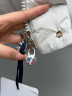 White puffer jacket zipper area with gold snap and metal key charm