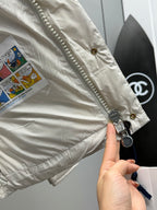 White puffer jacket with zipper trim, button placket, and patch tags