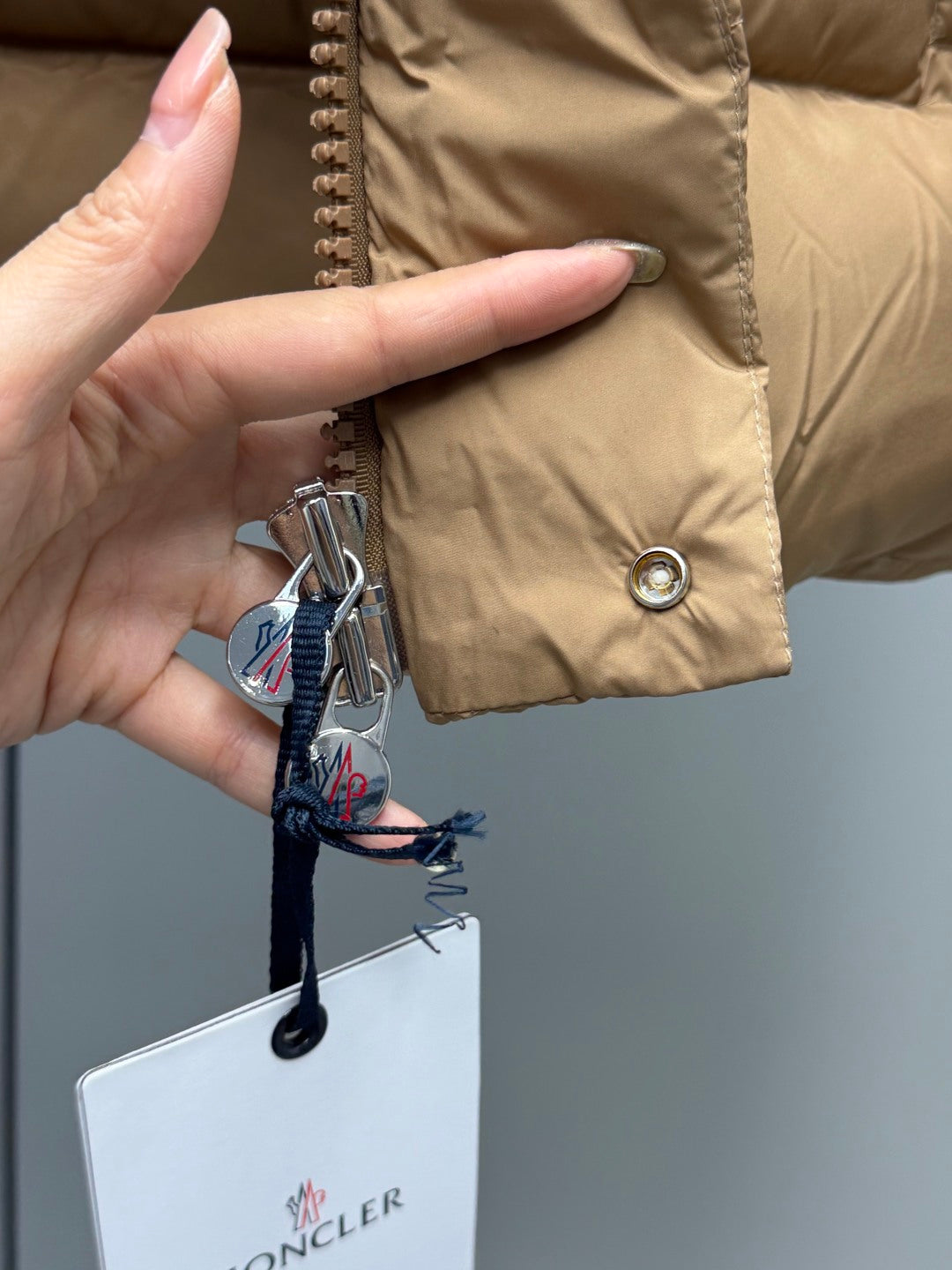 Moncler long puffer jacket tan with zipper pull and snap button closure