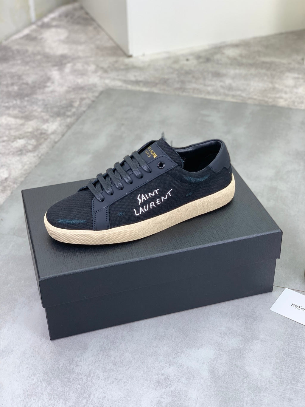 Navy SAINT LAURENT sneakers on a box, lace-up with beige rubber sole