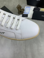 White sneaker toe and lace panel with green SAINT LAURENT logo detail.