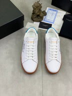 Pair of white leather sneakers with blue heel detail and brown gum soles