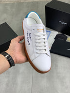 White leather low-top sneaker with blue heel tab and brown gum sole