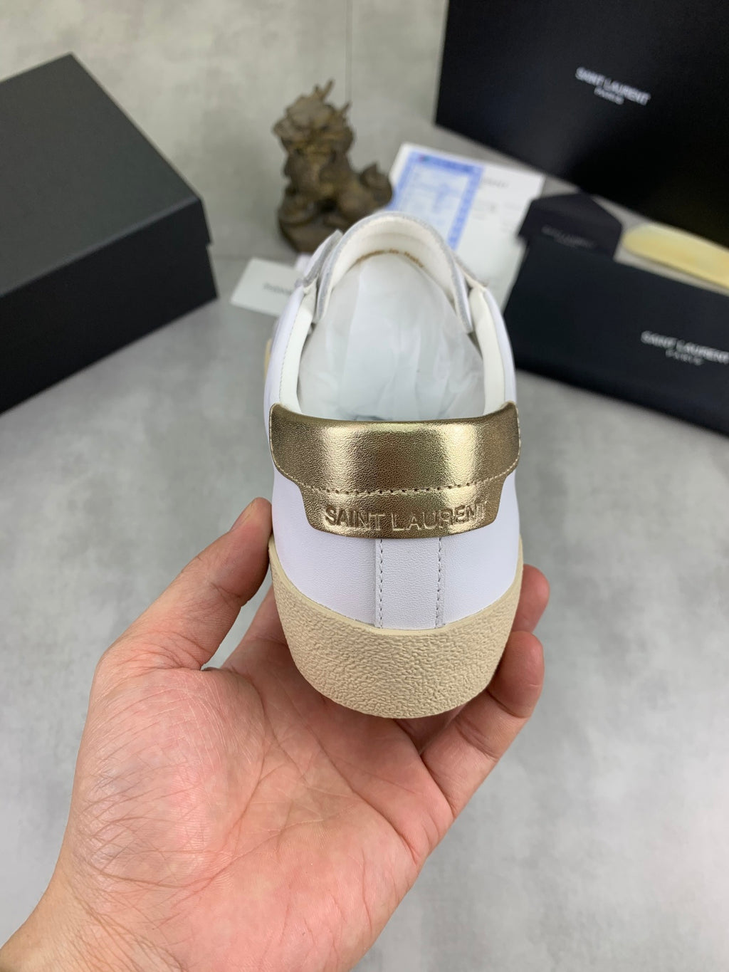 YSL unisex sneakers back view, white heel with gold trim and tan gum sole.