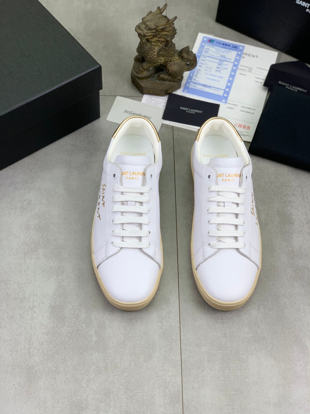 YSL unisex sneakers pair, white uppers with lace-up design and tan gum soles.